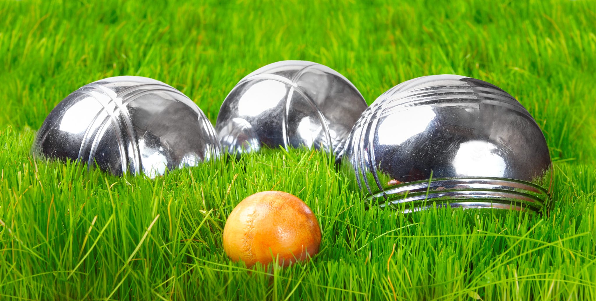 The petanque balls on a green grass.